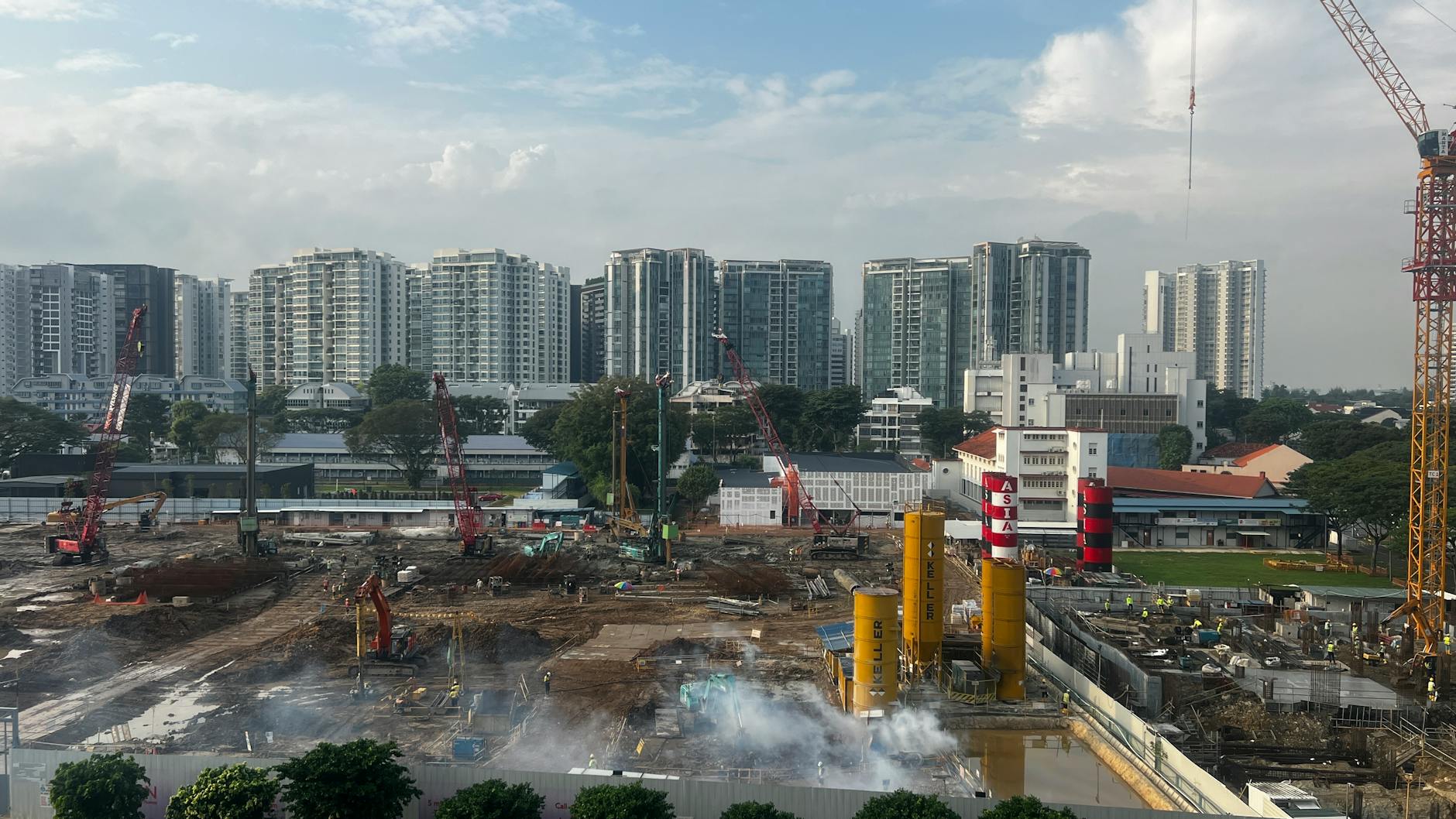 a construction site with cranes and buildings in the background